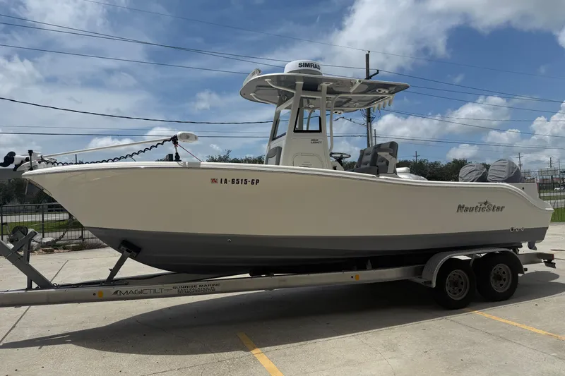 Slide: The Image of 2021 NauticStar 2602 Legacy boat on trailer under blue sky. - 5
