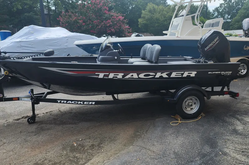 The Image of 2026 Tracker Super Guide V-16 SC boat on trailer, parked outdoors. - 0