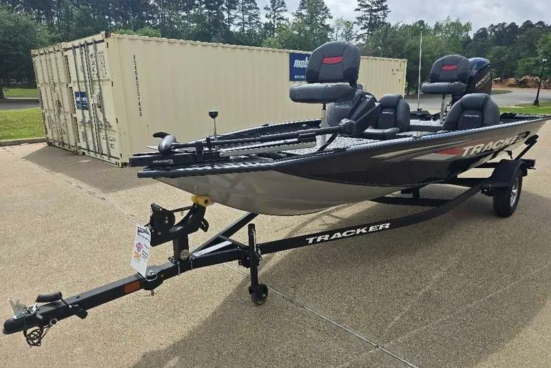 The Image of 2026 Tracker Pro Team 175 boat on trailer, parked outdoors near shipping containers. - 0