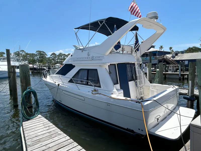 The Image of 1997 Bayliner 3788 Command Bridge Motoryacht docked at marina with American flag. - 0