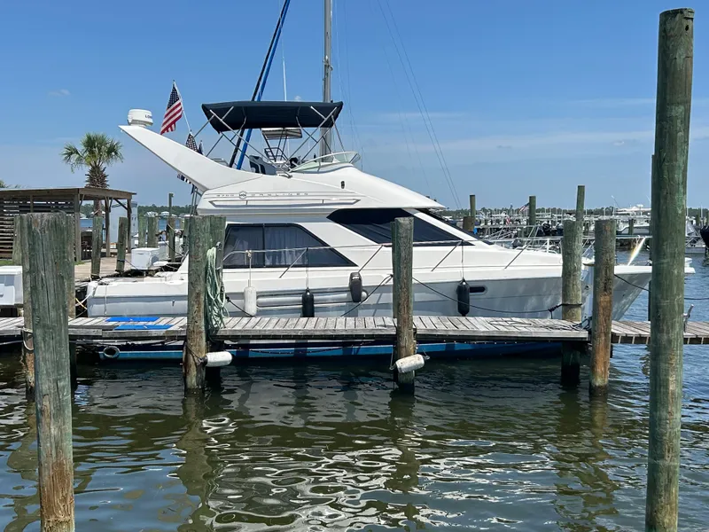 Slide: The Image of 1997 Bayliner 3788 Command Bridge Motoryacht docked at marina under clear blue sky. - 1
