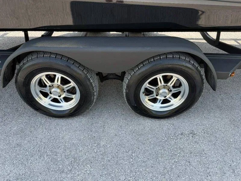 Slide: The Image of 2018 Scarab 255 ID Wake Ed trailer wheels on asphalt. - 25