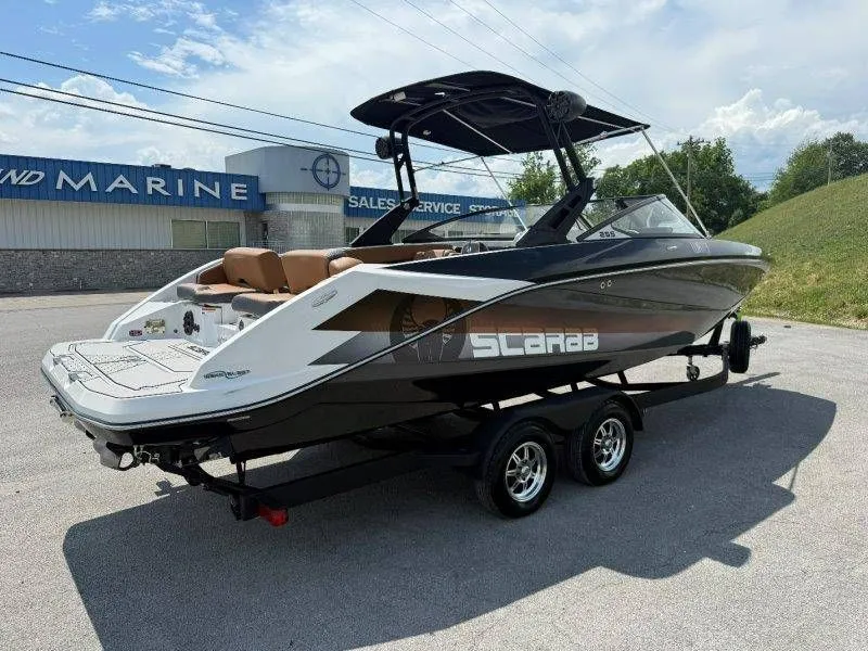 Slide: The Image of 2018 Scarab 255 ID Wake Ed boat on trailer outside marine shop. - 29