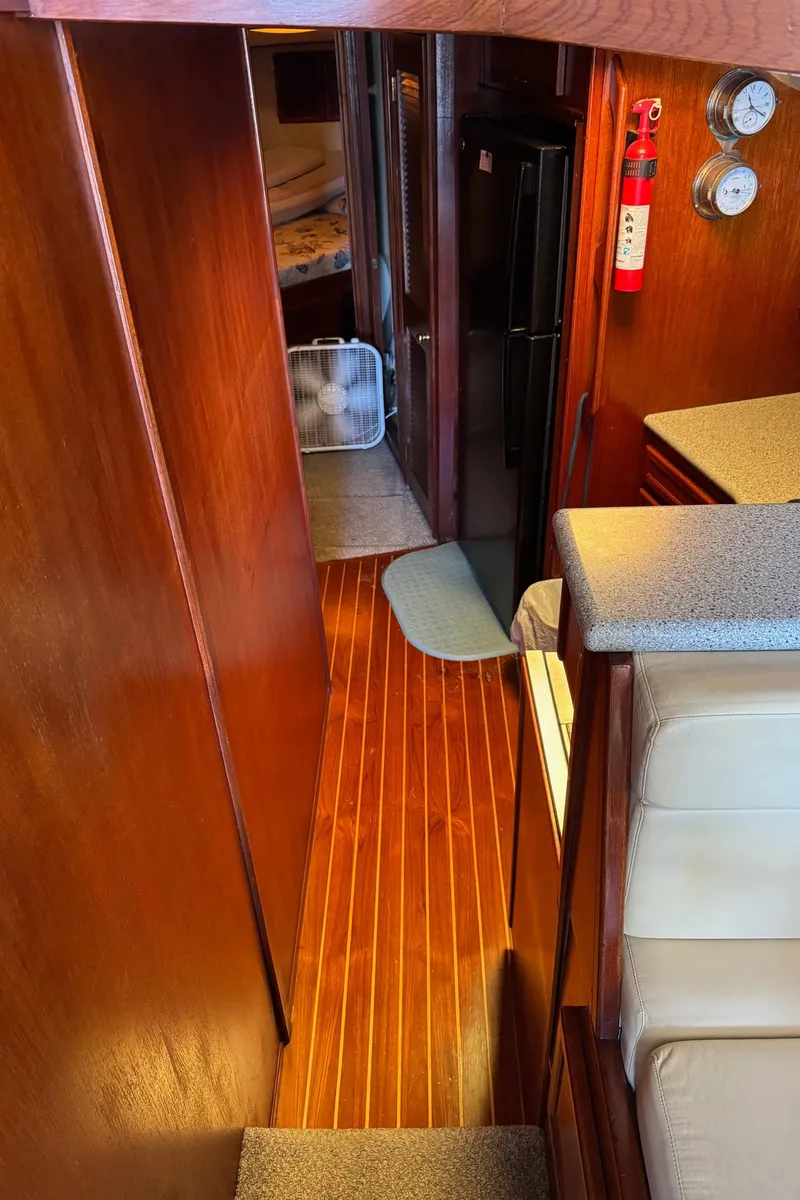 Slide: The Image of Interior of 1982 Viking 46 Convertible yacht with wooden flooring and compact kitchen area. - 12