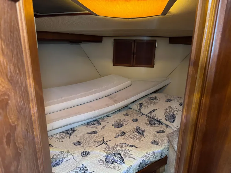 Slide: The Image of Cozy cabin interior of 1982 Viking 46 Convertible with nautical-themed bedding. - 15