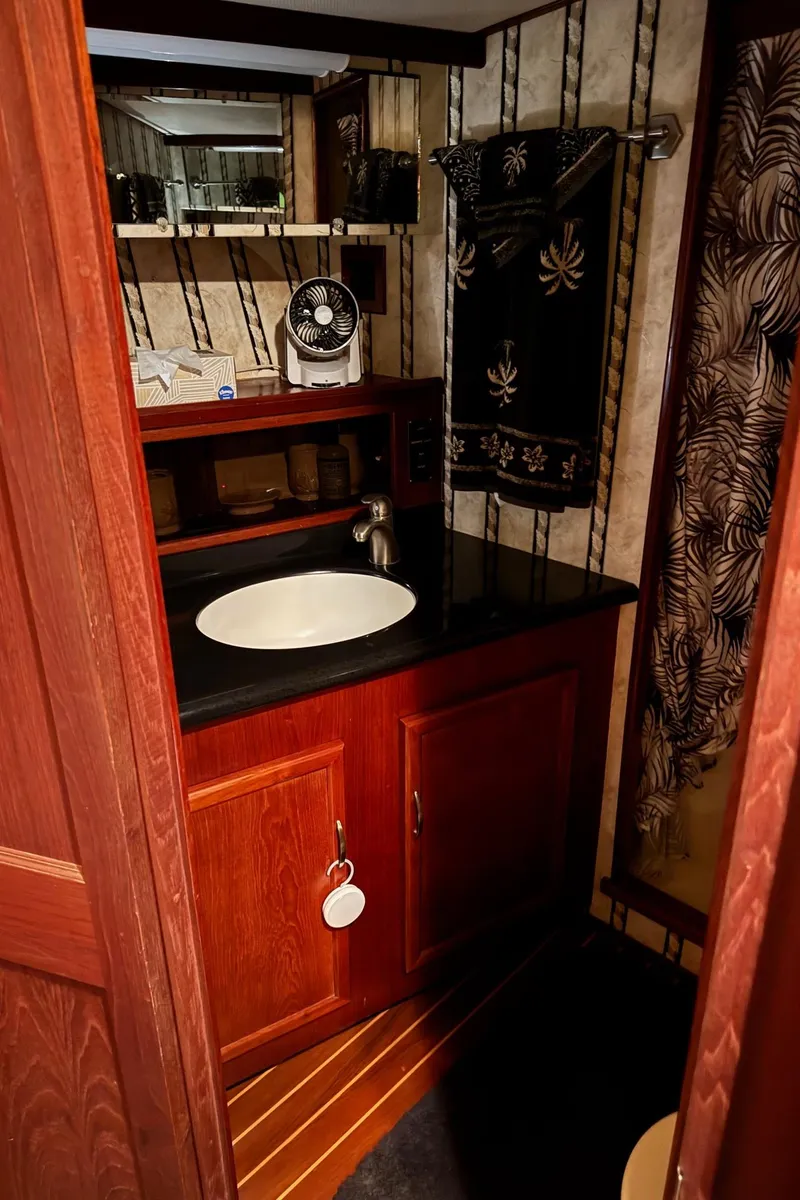Slide: The Image of 1982 Viking 46 Convertible bathroom with wood cabinetry and black countertop. - 17