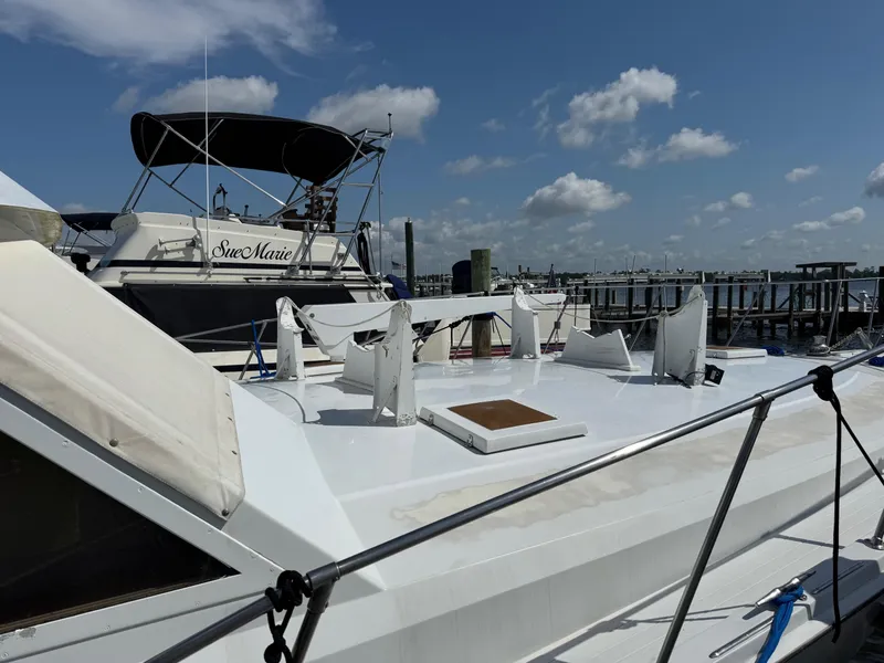 Slide: The Image of 1982 Viking 46 Convertible yacht docked at marina under blue sky. - 3