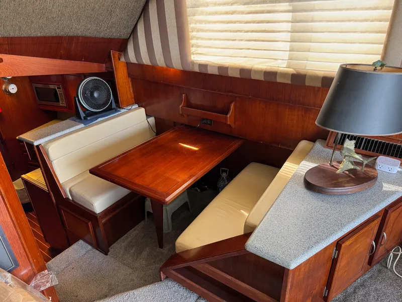 Slide: The Image of 1982 Viking 46 Convertible interior with dining area, wooden table, and cozy seating. - 9