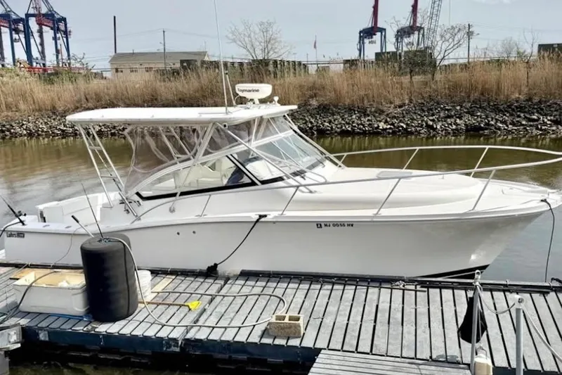 The Image of 2004 Luhrs 30 Open boat docked at marina with industrial background. - 0
