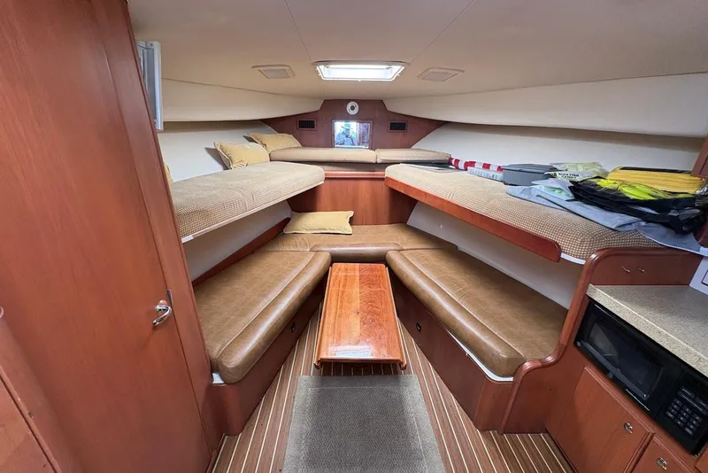 Slide: The Image of 2004 Luhrs 30 Open cabin interior with wooden finishes and comfortable seating. - 10
