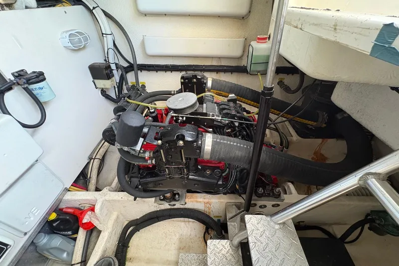 Slide: The Image of Engine compartment of a 2004 Luhrs 30 Open boat, showcasing mechanical components and wiring. - 14