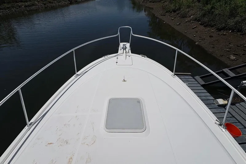 Slide: The Image of Bow view of 2004 Luhrs 30 Open boat docked by a calm riverbank. - 3