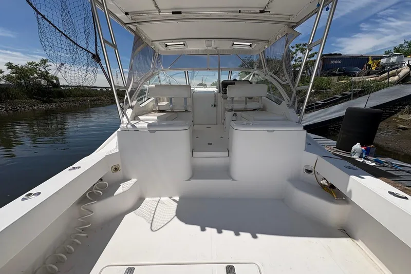 Slide: The Image of 2004 Luhrs 30 Open boat interior with seating and helm, docked by the water. - 5