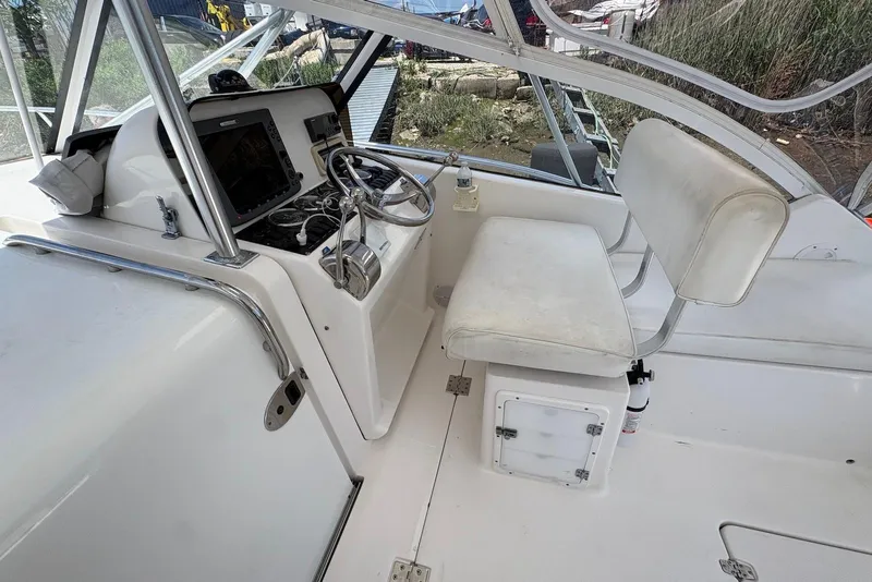 Slide: The Image of 2004 Luhrs 30 Open boat cockpit with steering wheel and seating area. - 8