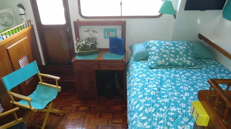 Slide: The Image of Cozy cabin interior of 1979 Universal Marine 41 with turquoise decor and wooden furnishings. - 11