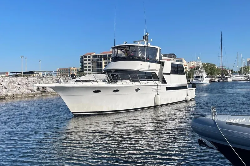 The Image of 1991 Californian 55 Cockpit Motor Yacht docked in a marina under clear blue skies. - 0