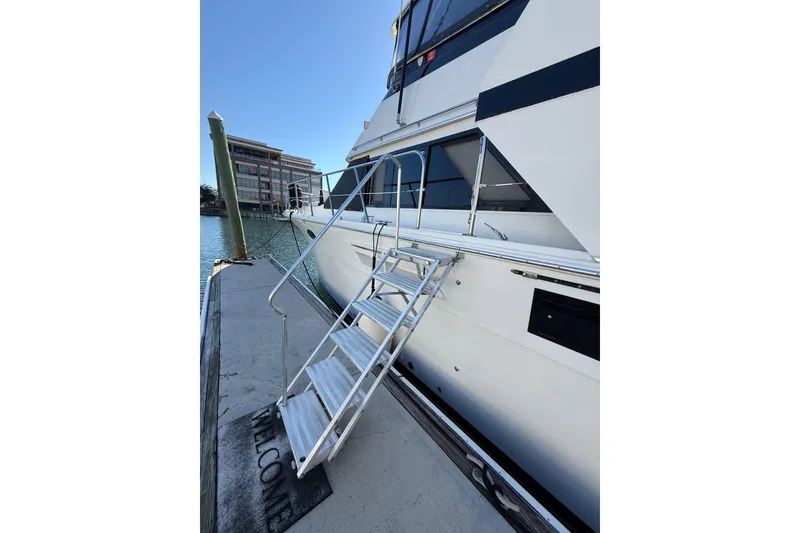 Slide: The Image of 1991 Californian 55 Cockpit Motor Yacht docked with boarding ladder and welcome mat. - 10
