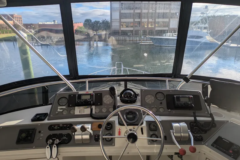 Slide: The Image of Cockpit view of 1991 Californian 55 Cockpit Motor Yacht with marina backdrop. - 23