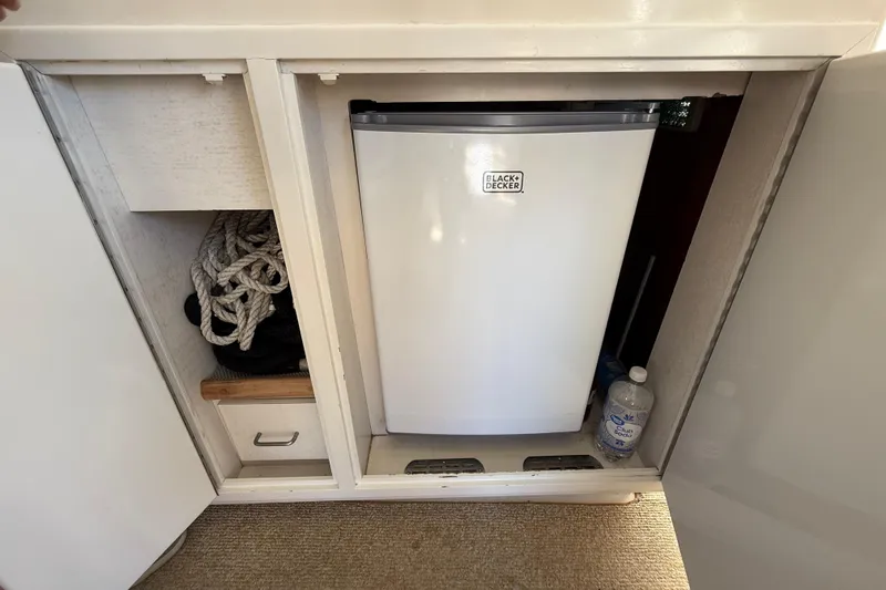 Slide: The Image of Compact fridge and storage in 1991 Californian 55 Cockpit Motor Yacht interior. - 34