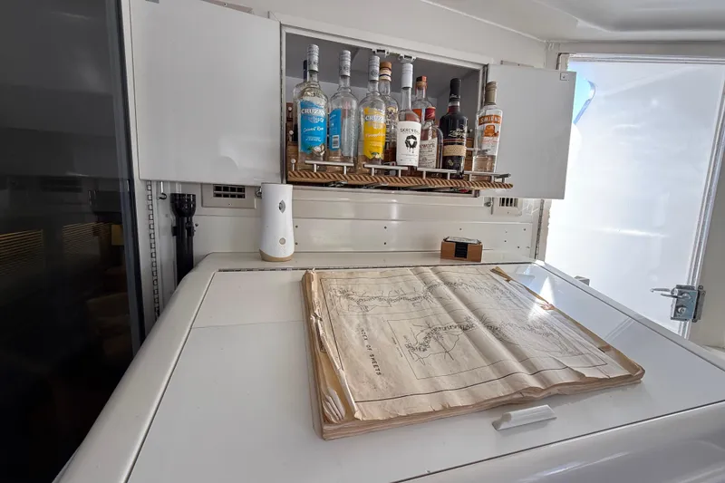 Slide: The Image of 1991 Californian 55 Cockpit Motor Yacht interior with liquor cabinet and nautical chart. - 36