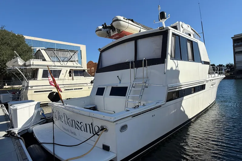 Slide: The Image of 1991 Californian 55 Cockpit Motor Yacht docked in a marina under clear blue skies. - 4