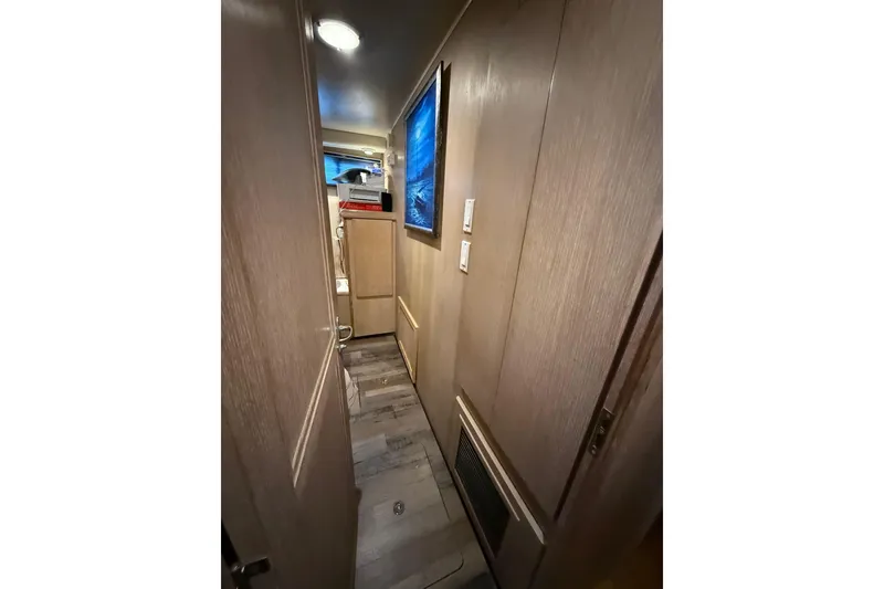 Slide: The Image of Narrow hallway inside 1991 Californian 55 Cockpit Motor Yacht with wooden paneling and modern decor. - 49