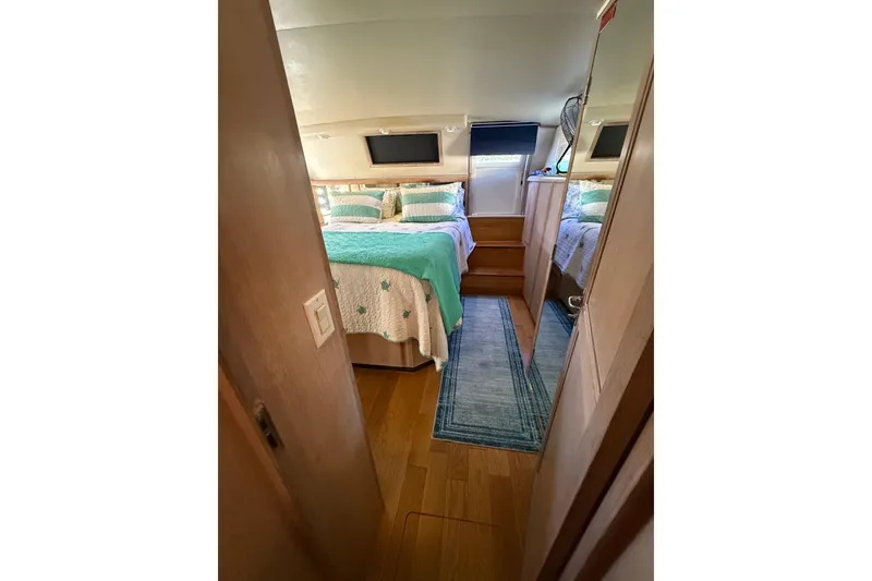 Slide: The Image of 1991 Californian 55 Cockpit Motor Yacht bedroom with cozy bedding and wooden flooring. - 51