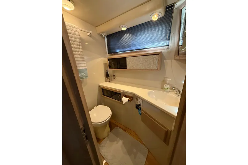 Slide: The Image of Bathroom interior of 1991 Californian 55 Cockpit Motor Yacht, featuring sink and toilet. - 53