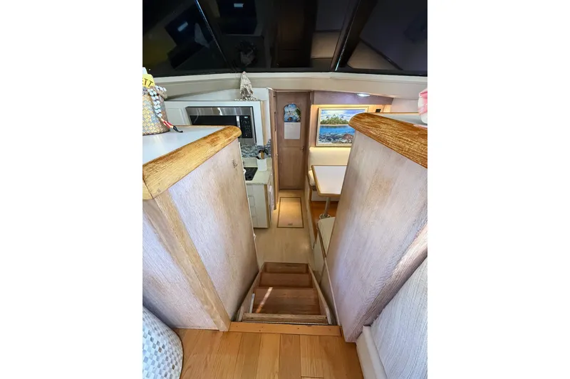 Slide: The Image of Interior of 1991 Californian 55 Cockpit Motor Yacht with wooden stairs and cozy dining area. - 55