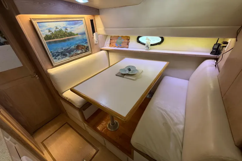 Slide: The Image of Cozy dining area in 1991 Californian 55 Cockpit Motor Yacht with artwork and porthole. - 60