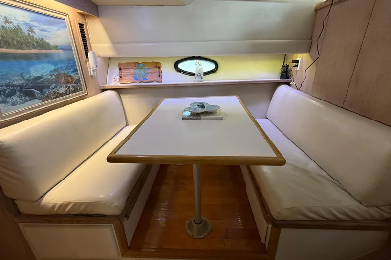 Slide: The Image of 1991 Californian 55 Cockpit Motor Yacht interior with cozy dining area and ocean-themed decor. - 61