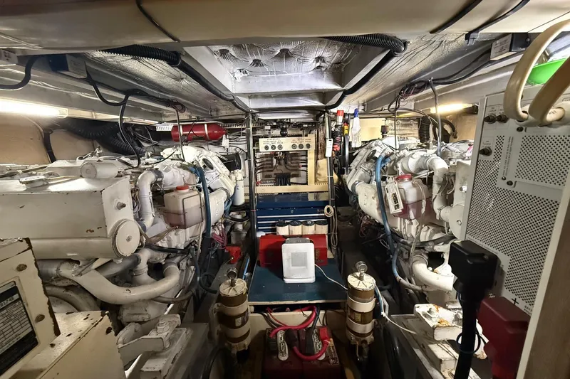Slide: The Image of Engine room of a 1991 Californian 55 Cockpit Motor Yacht, showcasing dual engines and equipment. - 70