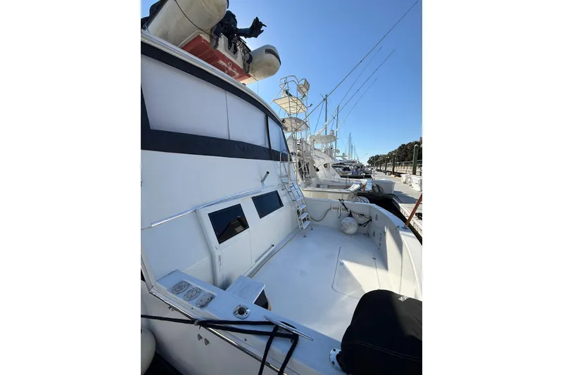 Slide: The Image of 1991 Californian 55 Cockpit Motor Yacht docked, showcasing spacious deck and sleek design. - 8