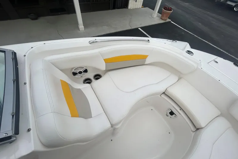 Slide: The Image of 2008 Chaparral Sunesta 244 boat interior with white and yellow seating, cup holders, and speaker. - 11