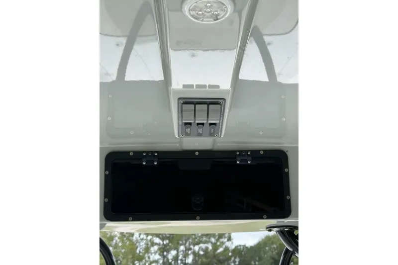Slide: The Image of 2022 BlackJack 256 Bay boat console with switches and storage compartment. - 9