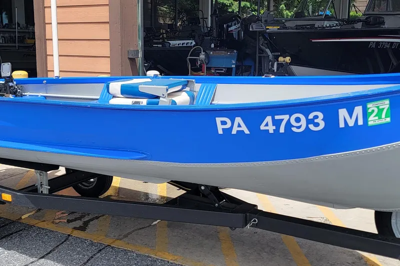 The Image of 1966 Sea Nymph V-14 boat in blue and gray on a trailer. - 1