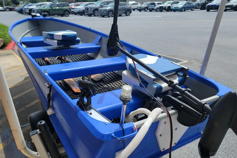 Slide: The Image of 1966 Sea Nymph V-14 boat with blue interior and modern equipment in a parking lot. - 6