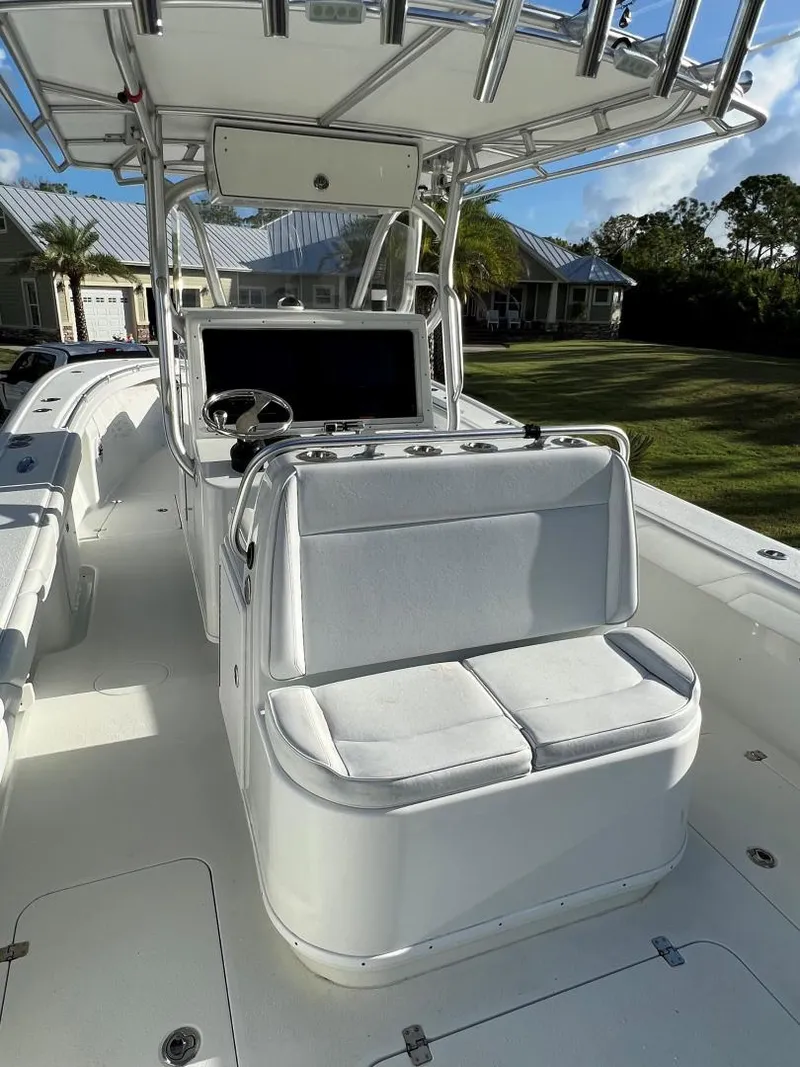 Slide: The Image of 2016 Yellowfin 32 Offshore boat with white seating and console, set against a sunny backdrop. - 11