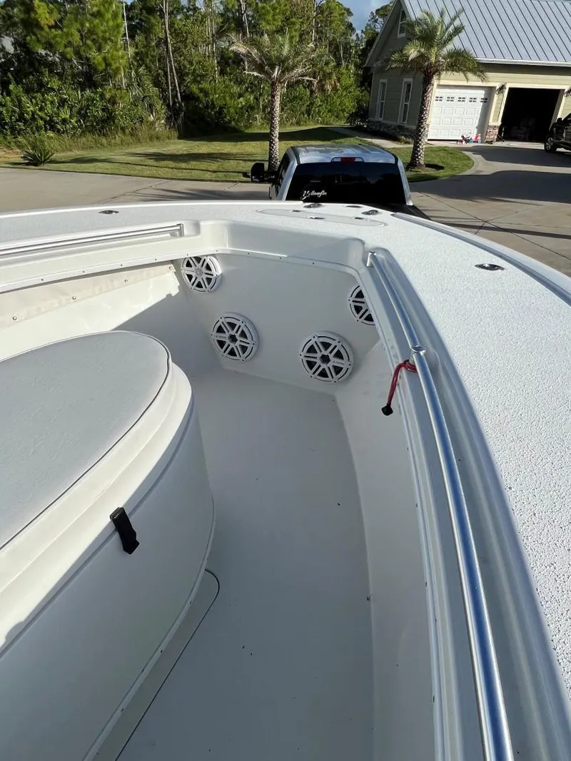 Slide: The Image of 2016 Yellowfin 32 Offshore boat interior with speakers, parked in a residential driveway. - 4