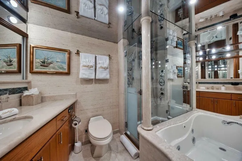Slide: The Image of Luxurious yacht bathroom with elegant fixtures, glass shower, and jacuzzi tub on 2002 Westport 112. - 20