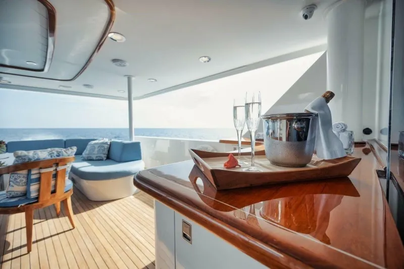 Slide: The Image of Luxurious 2002 Westport 112 yacht deck with champagne, ocean view, and elegant seating. - 31