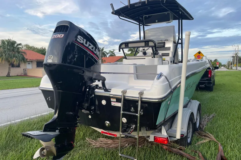 Slide: The Image of 2019 Key Largo 2100 CCW boat with Suzuki 200 engine on a trailer, parked roadside. - 5
