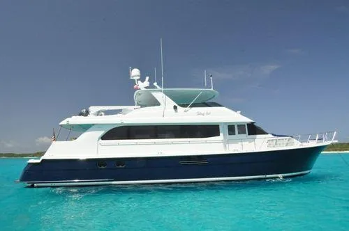 Slide: The Image of 2002 Hatteras Motor Yacht on turquoise water under clear blue sky. - 1