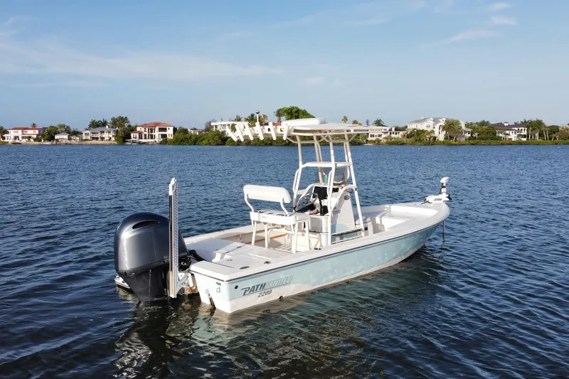 Slide: The Image of 2017 Pathfinder 2200 TRS boat on calm water, with waterfront homes in the background. - 11