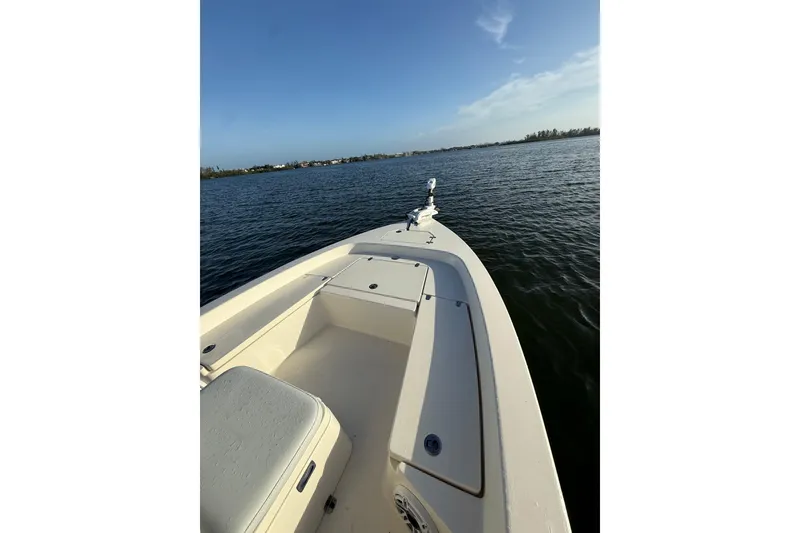 Slide: The Image of 2017 Pathfinder 2200 TRS boat on calm water under clear blue sky. - 13