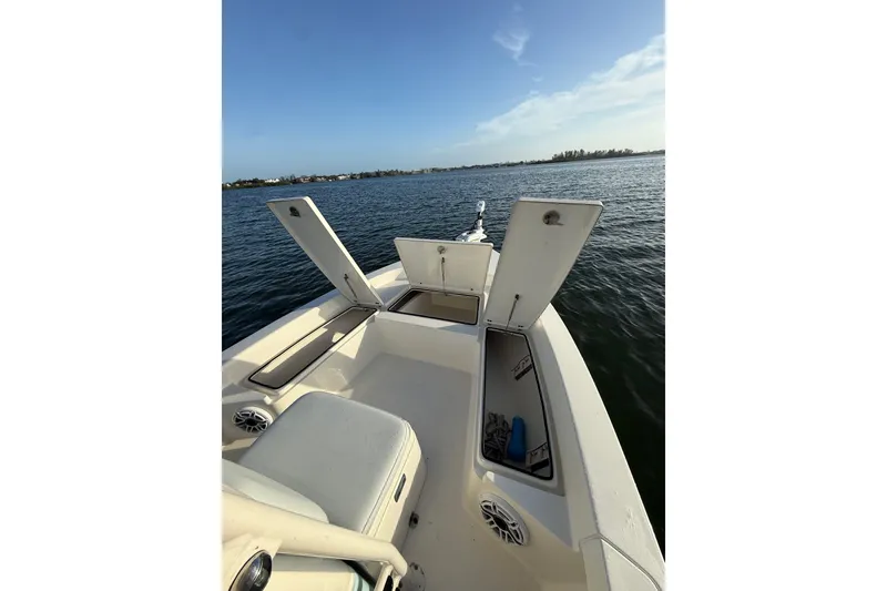 Slide: The Image of 2017 Pathfinder 2200 TRS boat on water, open storage compartments, clear sky. - 14