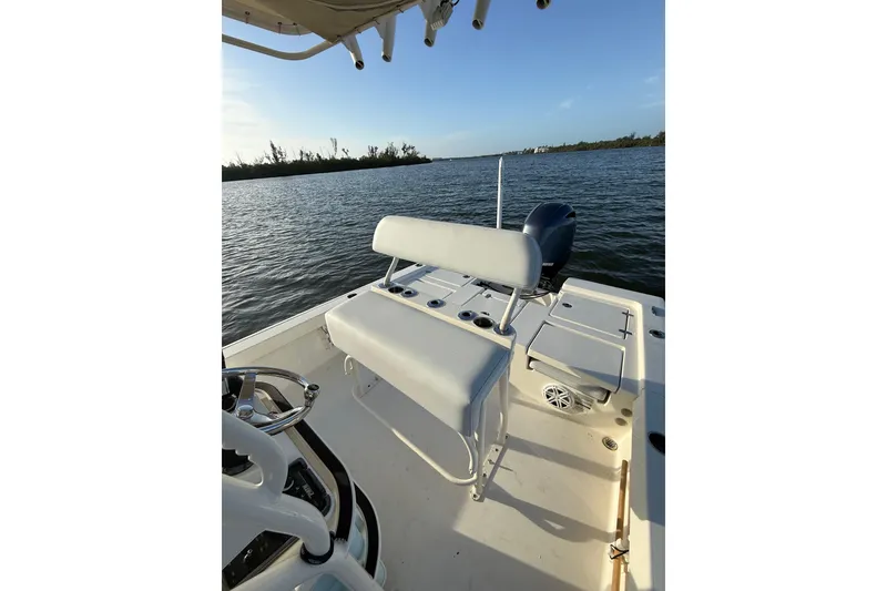 Slide: The Image of 2017 Pathfinder 2200 TRS boat interior with seating, steering wheel, and water view. - 18