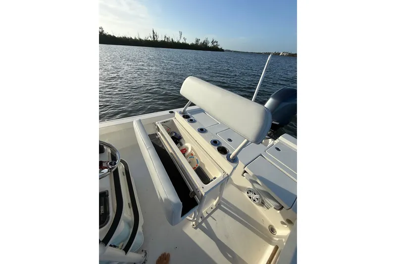 Slide: The Image of 2017 Pathfinder 2200 TRS boat interior with storage compartment open on calm water. - 19