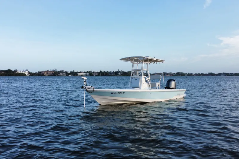 Slide: The Image of 2017 Pathfinder 2200 TRS boat on calm water under clear blue sky. - 2