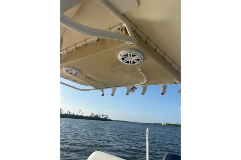Slide: The Image of 2017 Pathfinder 2200 TRS boat canopy with speakers, overlooking calm waters. - 20